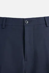 Pantalón de vestir azul marino, de corte slim fit, con bolsillos laterales y traseros de doble vivo con botón. Se ajusta a la cintura con cierre frontal con cremallera y botón.