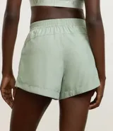 Short deportivo femenino modelo runner, color marrón chocolate con cintura elástica y rayas laterales color crema.