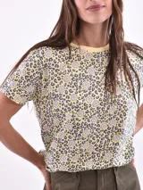 Remera blanca con estampado de flores y hojas en tonos pastel.