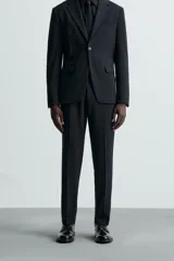 Pantalón de vestir gris oscuro, corte slim fit, confeccionado en tejido con 17% de lana. Cuenta con bolsillos frontales y traseros de vivo con botón. Cierre frontal con cremallera y botón.