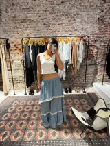 Pollera larga celeste con volados y detalles de puntilla blanca.