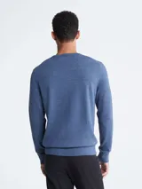 Sweater azul de lana merino con cuello redondo y logo bordado en el pecho.