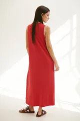 Vestido largo azul con cuello redondo y sisas con ribete color beige.