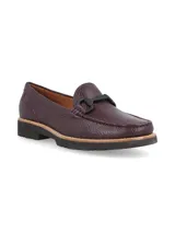 Mocasín de cuero negro con detalle de hebilla metálica plateada.
