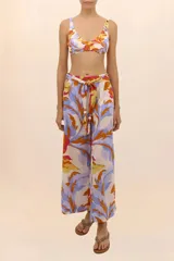 Pantalón de playa de pierna ancha con estampado floral en tonos celeste, naranja, amarillo y fucsia. Presenta cintura elástica y cinturón con cuentas.