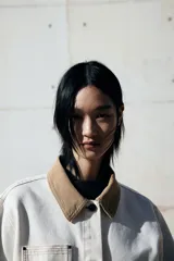 Campera de denim color crudo con cuello de pana color beige, con botones al frente, corte holgado, bolsillos superiores y bolsillos parche delanteros, hombros caídos y puños abotonados.