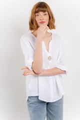 Blusa celeste de lino, con escote en V, manga tres cuartos y botón de madera.