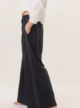 Pantalón de pierna ancha color azul marino con pespuntes a contratono (rojo/bordó) y una tira contrastante en el lateral.