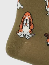 Calcetines largos color beige con diseño de perros de raza Basset Hound en diferentes poses. Algunos perros llevan sombreros de vaquero.