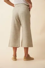 Pantalón palazzo color beige, de tiro alto, con bolsillos laterales y largo a la pantorrilla.