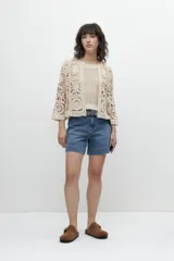Chaqueta corta color beige, tejida a crochet con diseño floral.
