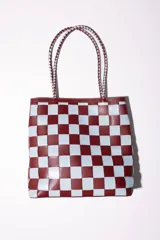 Bolso tipo tote de cuero tejido a mano con diseño a cuadros en color negro y tostado.