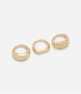 Set de tres anillos dorados de metal con efecto bold, uno texturizado y dos lisos con diferentes formas.
