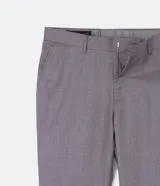 Pantalón de vestir gris, de corte slim fit, con bolsillos laterales y traseros. Se ajusta a la cintura con cinturón de cuero negro.