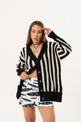 Saco oversize tejido a rayas verticales en blanco y negro, con escote en V y botones.