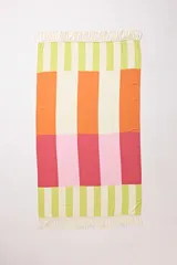 Pareo playero rectangular con estampado de bloques de colores: verde claro, naranja, rosa y blanco. Tiene flecos en los extremos.