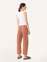 Pantalón color ladrillo de corte slouchy con cinco bolsillos y pinzas en las rodillas que estructuran la silueta con un aire urbano. Incluye metales en acabado níquel.