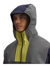 Campera deportiva impermeable Under Armour Halo Run Jacket, color gris con detalles en amarillo y azul marino. Cuenta con capucha, cierre frontal y bolsillos laterales con cierre.