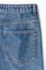 Jean de cinco bolsillos en denim de algodón rígido color celeste. Corte holgado en cintura y cadera con estilo baggy de muslo a bajo. Modelo de cintura clásica con cierre y botón y piernas rectas largas.