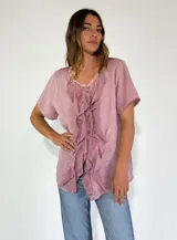 Camisa de lino y algodón color rosa claro, con cuello en V, mangas cortas y volados frontales.