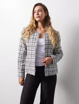 Chaqueta en tejido tweed a cuadrillé blanco y negro, marca Nanette. Cuello a la base y abertura central. Delantera con bolsillos aplicados. Manga larga, puño con botones. Terminación desflecada. Forro interno.