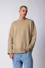 Sweater beige de hilo de algodón, corte oversize, con cuello redondo, puños y ruedo acanalados con pequeños desgastes. Espalda con logo tejido.