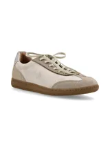 Zapatillas acordonadas de cuero color beige con suela de goma color caramelo y detalle plateado en el talón.