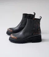 Botas Chelsea de cuero vacuno negro con elásticos laterales, cierre interno y suela de goma artesanal.