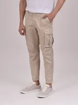 Pantalón cargo color beige, de corte recto y tiro medio, con bolsillos laterales con solapa y bolsillos delanteros y traseros.