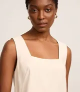 Blusa sin mangas color crema, confeccionada en viscosa, con escote cuadrado.