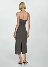 Vestido midi gris con finas rayas verticales blancas, de corte ajustado y sin mangas. Presenta escote strapless, detalle drapeado en la falda y abertura en la parte posterior.