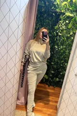 Conjunto deportivo beige de dos piezas, compuesto por un buzo de cuello alto y un pantalón jogger.