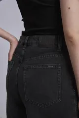 Bermuda de jean negro con tachas plateadas.