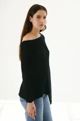 Poncho color beige de tejido de punto con cuello asimétrico.