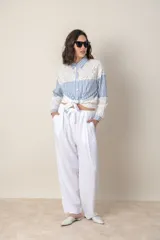 Camisa blanca de algodón con bordado calado y rayas celestes.