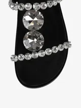 Sandalias negras con tiras adornadas con apliques brillantes y cierre con hebilla en el tobillo.