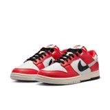 Championes Nike Dunk Bajo Retro Premium de hombre, color blanco y rojo con detalles en negro. Zapatillas de caña baja con cordones negros y suela color crema.