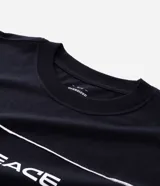 Remera oversized negra de algodón con cuello redondo, mangas cortas amplias y estampado frontal con la palabra "PEACE" en blanco, acompañada de dos líneas horizontales blancas.