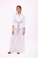 Blazer blanco con solapas con borde marrón, corte recto, mangas 3/4 y cinturón marrón.