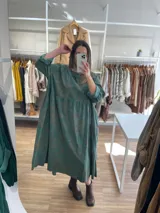 Vestido largo de pana fina color verde con estampado de flores marrones, corte oversize, mangas 3/4 y bolsillos laterales.