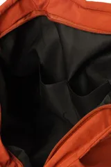 Bolso shopper color naranja con diseño acolchado y cierre superior.