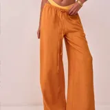 Pantalón palazzo color naranja, de tiro alto con cintura elastizada y cordón ajustable.