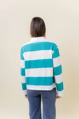 Sweater de manga larga con diseño de rayas anchas horizontales en azul marino y blanco. Posee cuello polo con cartera de botones y calce relajado.