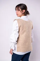 Chaleco color beige de tejido rústico con lazos laterales.