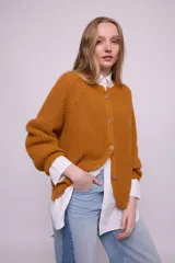 Cárdigan color ocre de tejido de punto con mohair, con cuello redondo, mangas largas y botones al tono. Silueta ligeramente oversize.