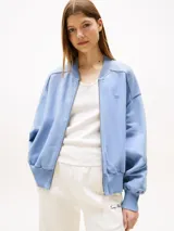 Campera bomber celeste de felpa con cierre frontal, cuello, puños y ruedo acanalados. Logo de Tommy Hilfiger bordado en el pecho y en el puño.