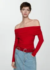 Camiseta roja con hombros descubiertos, cuello con volantes, mangas largas y corte ajustado.