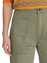 Pantalón de jeans verde militar, estilo cargo, de tiro alto, con bolsillos laterales y detalles de patchwork en dos tonalidades.