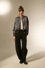 Campera estilo bomber de manga larga, con cuello mao y cierre frontal. Confeccionada en tejido de poliéster con estampado de piel de serpiente en tonos grises y negros.