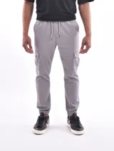 Pantalón jogger color gris con bolsillos cargo laterales, cintura elastizada con cordón de ajuste y puños elastizados.